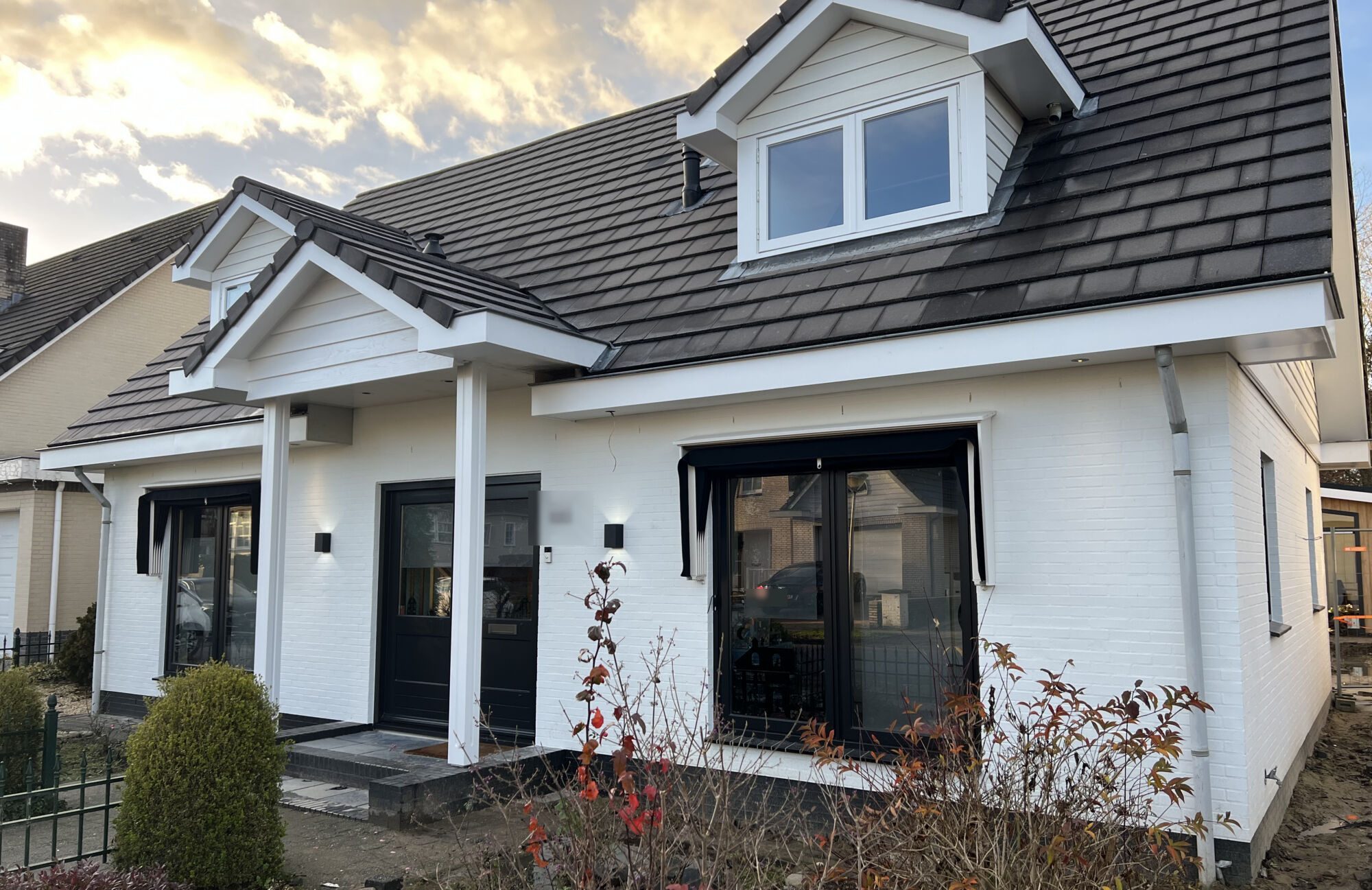 Wit geschilderde woning met dakkapel, opgeleverd door Schildersbedrijf Cliteur