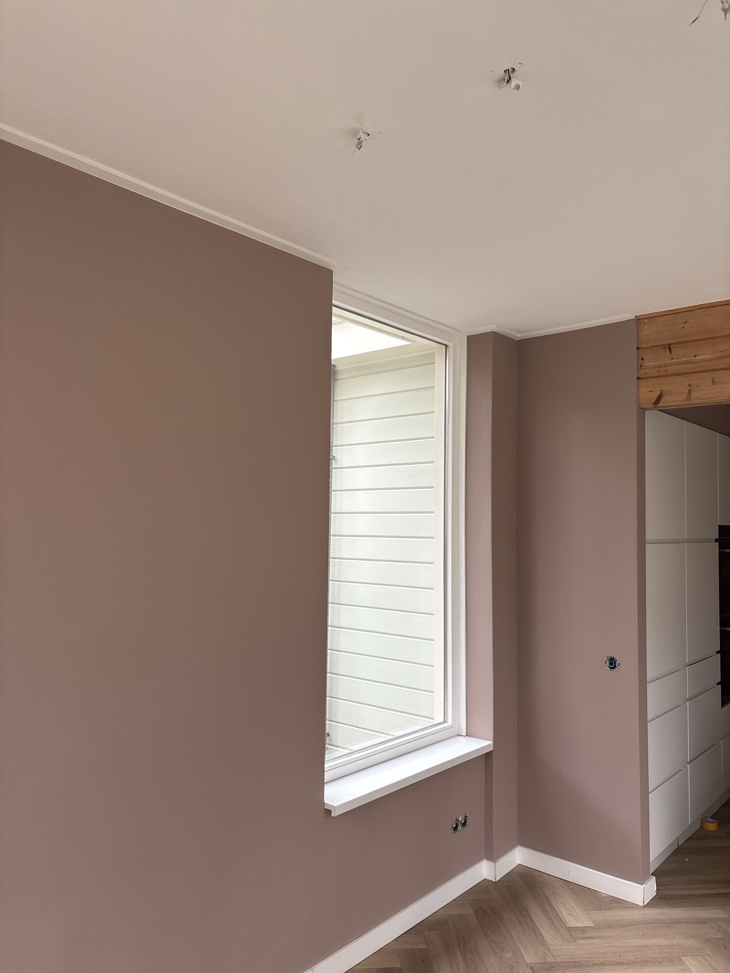 Woonkamer met wanden in kleur en een strak wit plafond